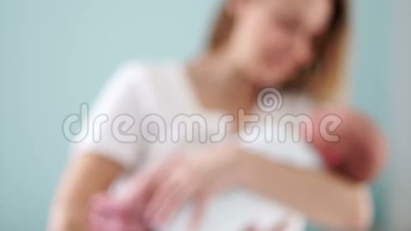 一个新生婴儿在母亲怀里妈妈和她的孩子母亲节轻轻地抚摸着她孩子的头慢慢视频的预览图