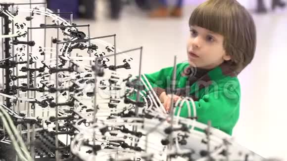 儿童与机器人机器人展览上一个好奇的男孩现代玩具孩子和未来虚拟游戏视频的预览图
