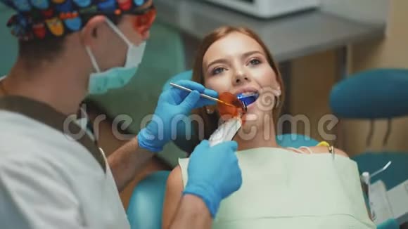 年轻漂亮的女孩正在牙科治疗和牙科清洗4K视频的预览图