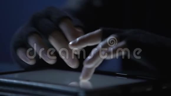 在平板触摸屏上特写罪犯的手滚动页面网络犯罪视频的预览图
