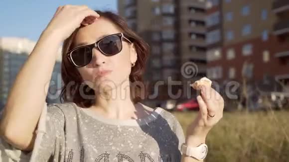 一个戴太阳镜的女人正在吃冰淇淋视频的预览图
