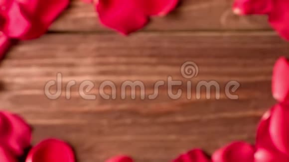 散落在木地板上的红色玫瑰花瓣视频的预览图