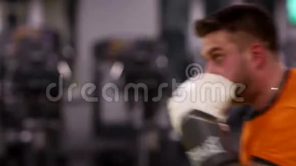 一个男人在健身房打一个拳击袋视频的预览图