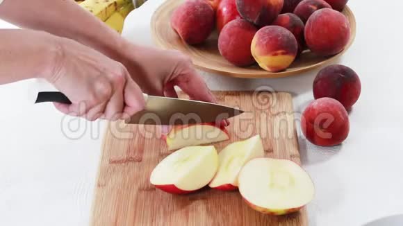 苹果切片女人在木切割板上切苹果贴在白色背景上视频的预览图