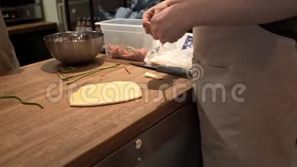 厨师在餐馆里把绿色面团条纹放在白色面团上视频的预览图
