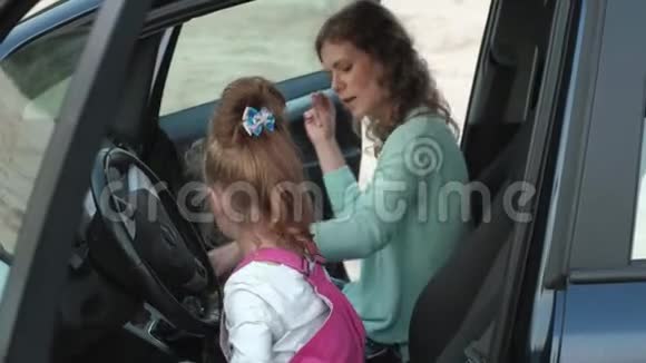 秋天妈妈和女儿在汽车旁边的狂野海洋前跳舞和跳跃快乐视频的预览图