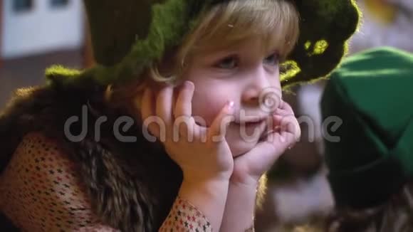 一个戴着针织帽子的可爱金发男孩坐在一个女孩旁边房间里有圣诞装饰动作缓慢视频的预览图