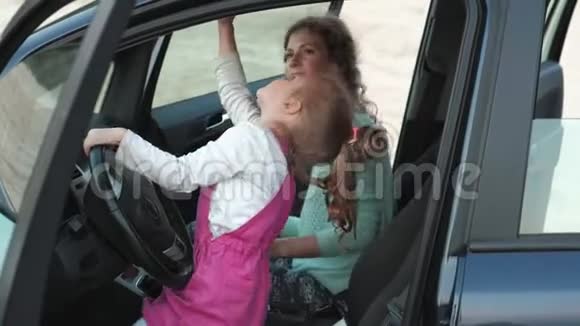 秋天妈妈和女儿在汽车旁边的狂野海洋前跳舞和跳跃快乐视频的预览图