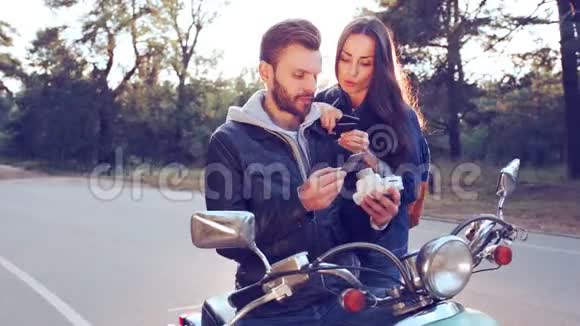 一对骑摩托车的人正在检查即时照片视频的预览图