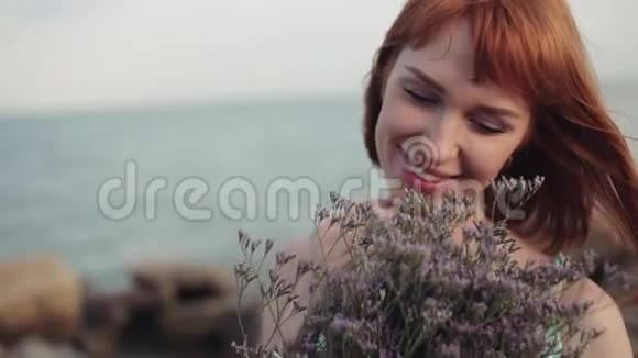 肖像慢镜头拍摄在阳光明媚的天气里美丽的女孩带着一束鲜花美丽的微笑视频的预览图