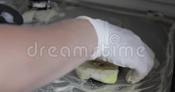 使用海绵清洁厨房灶具时女性手戴手套视频的预览图
