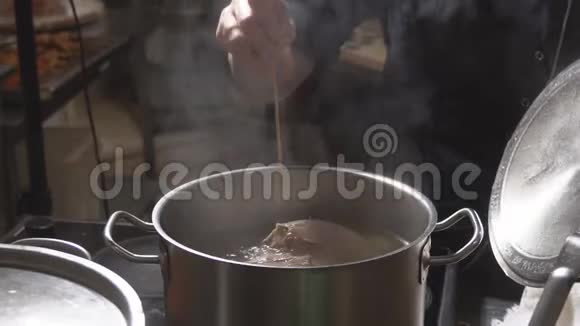冒泡的肉汤在一个金属锅内在一家餐馆的厨房视频的预览图