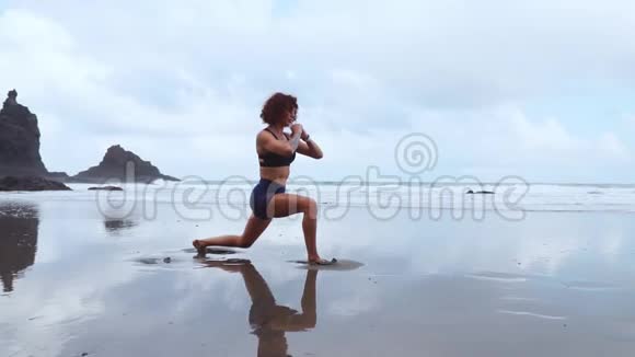 美丽的运动女郎穿着运动服在海洋低潮后做运动来热身和调整肌肉这就是视频的预览图