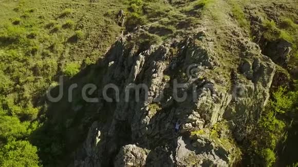 在悬崖上自由攀爬的人的空中景观男性攀爬岩石时没有安全线束和绳索爬进去视频的预览图