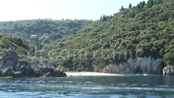 在科孚岛的天堂海滩区与一艘船罗维尼亚海滩擦肩而过海滩上的人位于利帕德斯村旁边视频的预览图