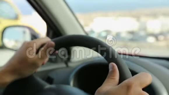 男性驾驶汽车双手放在方向盘上靠在挡风玻璃上特写镜头视频的预览图
