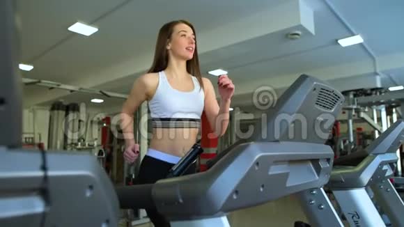 健身运动女孩正在运动健身房的跑步机上跑步视频的预览图