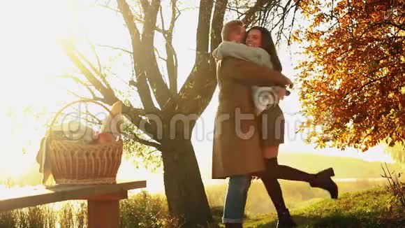 一对夫妇在日落时在寒冷的一天在湖边散步的肖像也许他们有周年纪念秋天视频的预览图