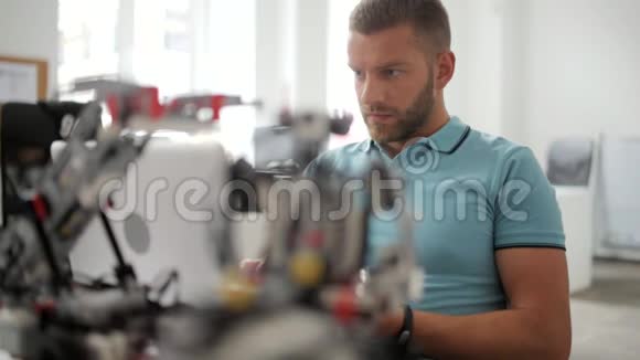 男性工程师在笔记本电脑上输入有关机器人的信息视频的预览图