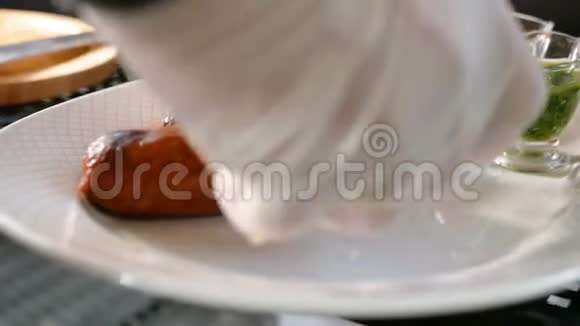 厨师仔细调整准备好的香肠在一个盘子附近的各种酱汁烧烤的肉菜视频的预览图