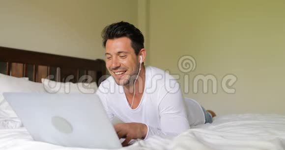 年轻人用笔记本电脑进行视频聊天打电话给说话的人早上躺在床上视频的预览图