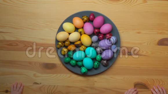 孩子们从盘子里拿出多种颜色复活节彩蛋的时间视频的预览图