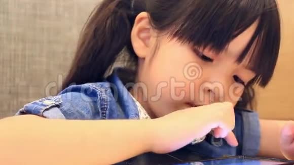 可爱的亚洲女孩玩智能手机视频的预览图