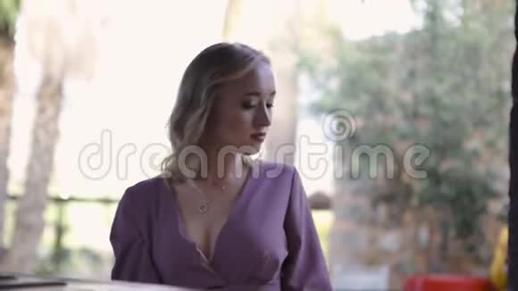 一个年轻的金发女人坐在家里厨房的肖像艺术年轻漂亮的金发女郎坐在厨房里视频的预览图