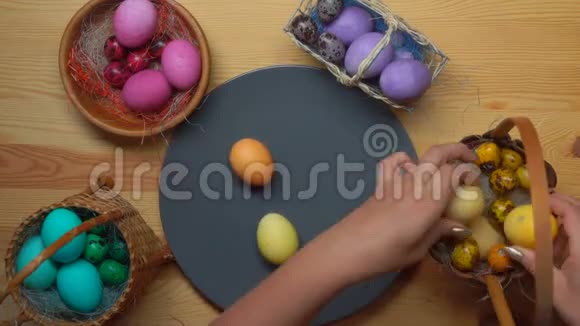 女人手从不同的篮子里拿出彩色复活节彩蛋视频的预览图