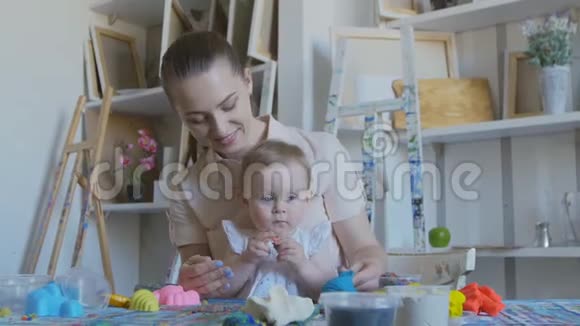 一位年轻开朗的母亲和她的孩子在玩软塑料宝宝试着吃塑料视频的预览图