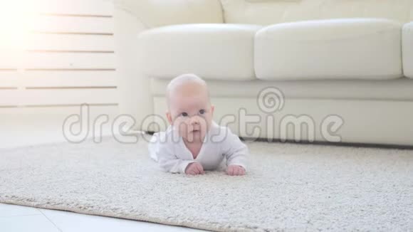可爱有趣的宝宝躺在米色地毯上视频的预览图