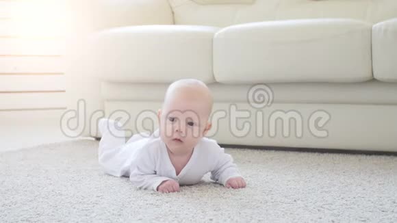 可爱有趣的宝宝躺在米色地毯上视频的预览图
