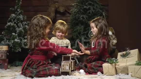 三个小朋友坐在礼物中间拍拍手慢动作视频的预览图