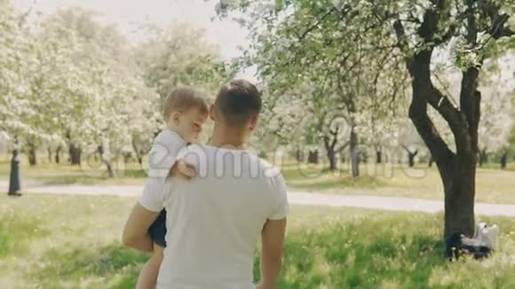 父子在公园散步年轻的父亲和小儿子在户外玩得很开心视频的预览图