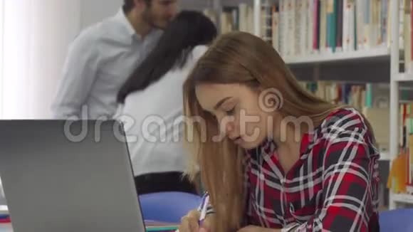 图书馆笔记本电脑上的女孩笔记视频的预览图