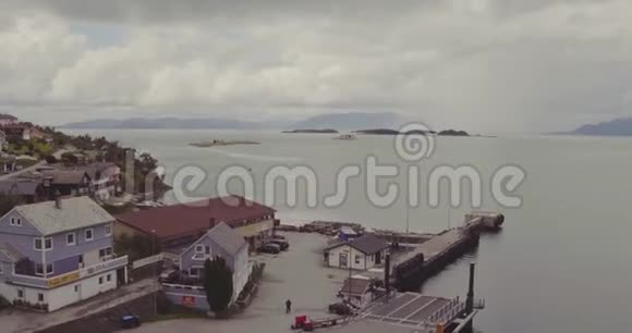 在阴云密布的天空下散落在峡湾沿岸的村庄房屋视频的预览图