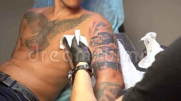 纹身师在鼓手和鼓槌的手像上做消毒纹身视频的预览图