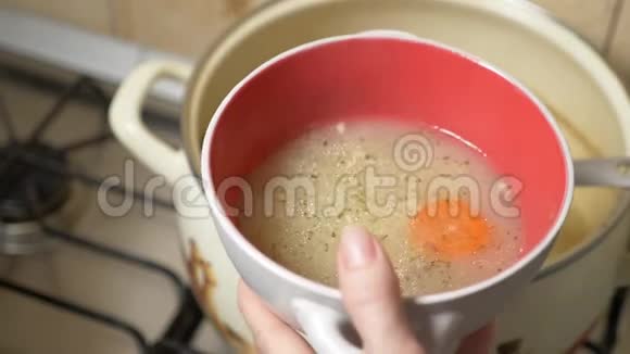 有人把炖锅里的鸡汤倒进碗里4k慢动作视频的预览图