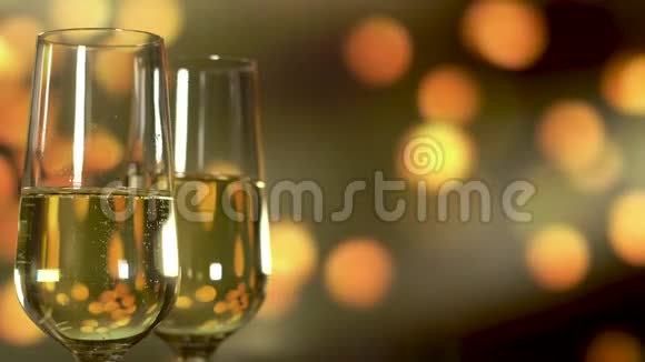 两杯香槟金色闪烁的背景上有气泡视频的预览图