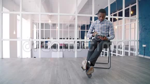 年轻的商人坐在领导公司时使用平板电脑视频的预览图