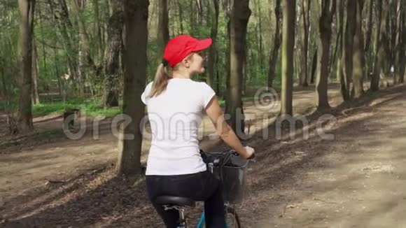 动作缓慢女人骑自行车女青少年骑自行车在阳光公园积极运动概念视频的预览图
