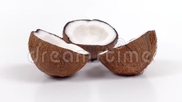 三个成熟的椰子半部分美味的果肉旋转在白色孤立的背景可循环无缝视频的预览图