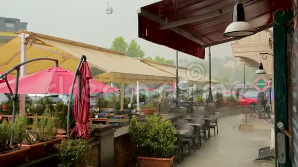 格鲁吉亚的气候在倾盆大雨中舒适的街头咖啡馆变得潮湿视频的预览图