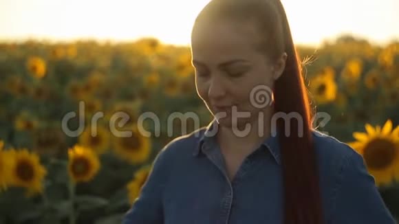 年轻漂亮的白种中年红发女子带着向日葵在田间打电话自拍视频的预览图