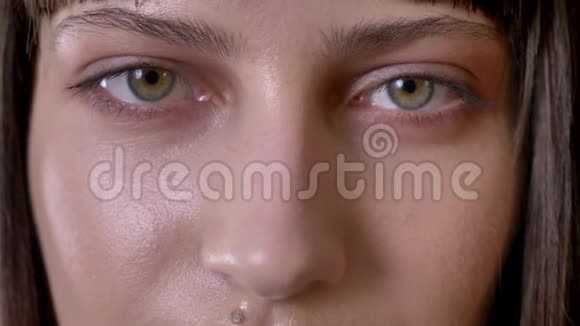 近镜头的年轻女子绿色的眼睛看着镜头视频的预览图