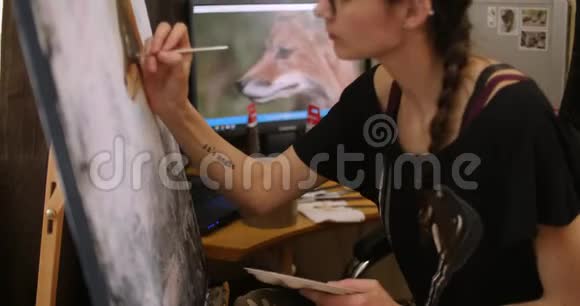 女孩艺术家画一只狐狸中等计划艺术家在4k车间用丙烯酸颜料绘制画布视频的预览图