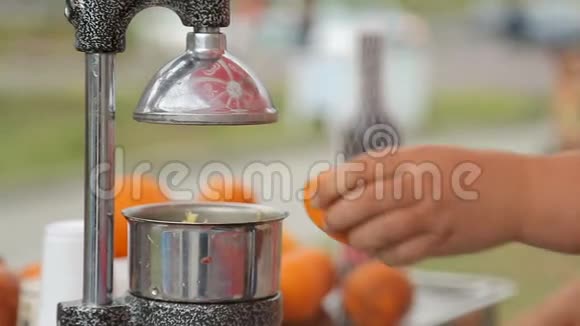 女街小贩熟练地从橙子里榨出新鲜果汁视频的预览图
