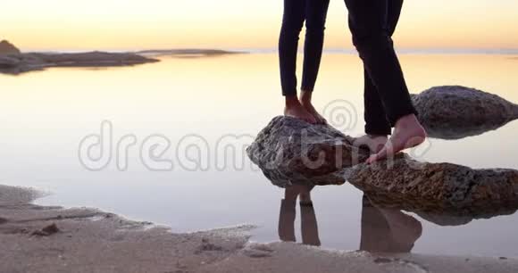 一对夫妇站在海边的岩石上视频的预览图