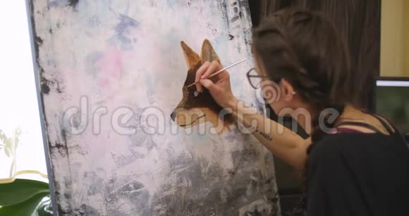 女孩艺术家画一只狐狸中等计划艺术家在她的车间里用丙烯酸颜料描绘画布上的画面视频的预览图