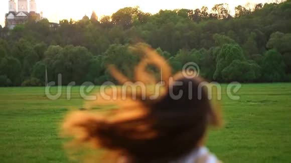 女孩穿着白色上衣和黑色紧身衣跑过田野视频的预览图